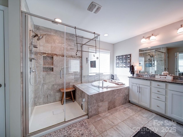 full bathroom with a healthy amount of sunlight, a garden tub, a shower stall, and vanity