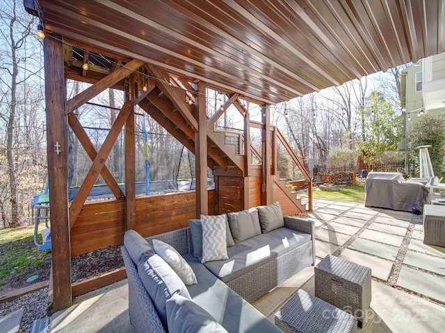 view of patio featuring grilling area, stairway, outdoor lounge area, and fence