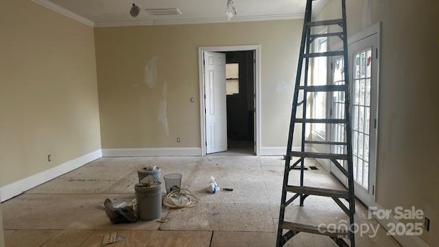 unfurnished room featuring ornamental molding, visible vents, and baseboards