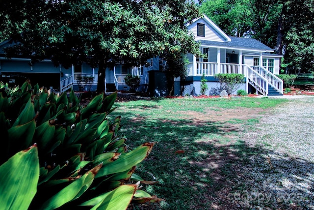 view of front of house with stairs, a porch, and a front lawn
