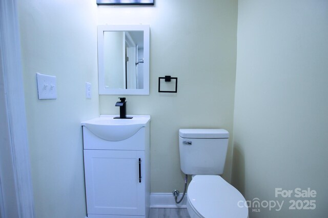 half bath featuring toilet and vanity