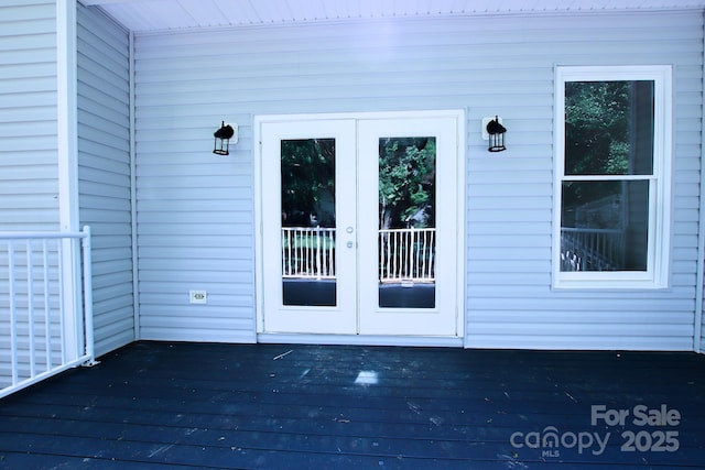 view of exterior entry featuring a deck and french doors