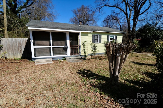 view of front of house with fence and a sunroom