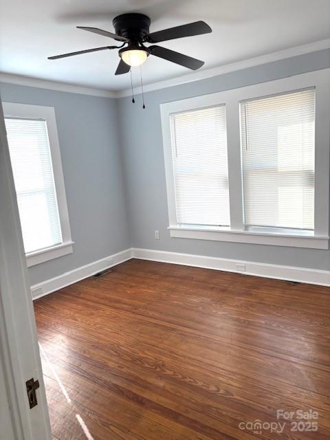 unfurnished room featuring baseboards, ornamental molding, ceiling fan, and dark wood-style flooring