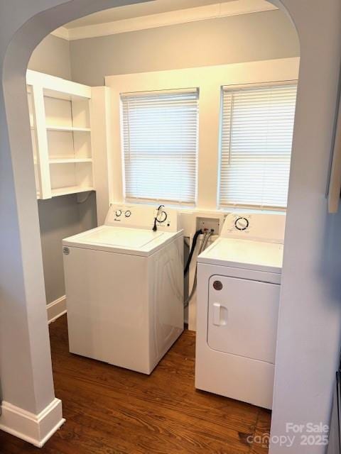 laundry area featuring laundry area, washing machine and dryer, arched walkways, and wood finished floors