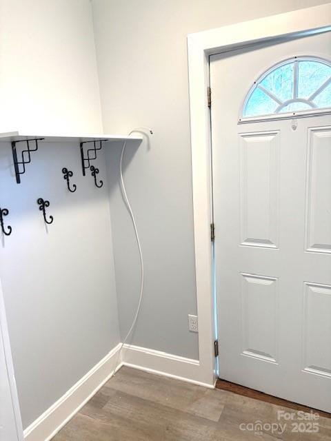 clothes washing area with light wood-type flooring, laundry area, baseboards, and washer hookup