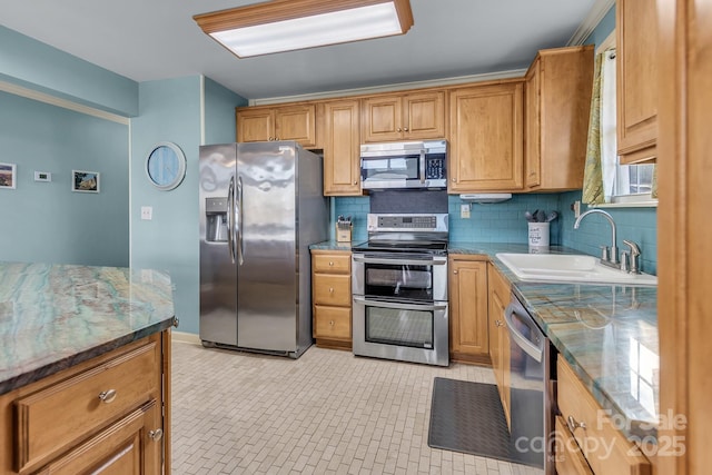 kitchen featuring backsplash, stone countertops, stainless steel appliances, and a sink