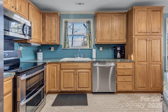 kitchen featuring tasteful backsplash, visible vents, appliances with stainless steel finishes, ornamental molding, and a sink