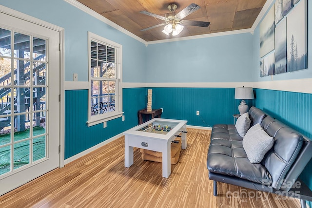 rec room featuring ceiling fan, wainscoting, wood finished floors, and crown molding