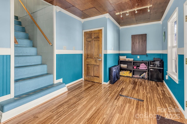 office space featuring a wainscoted wall, wood finished floors, rail lighting, and crown molding