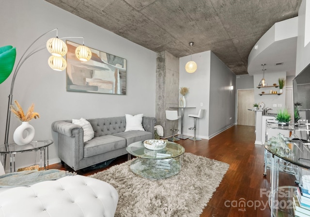 living area with visible vents, baseboards, and wood finished floors