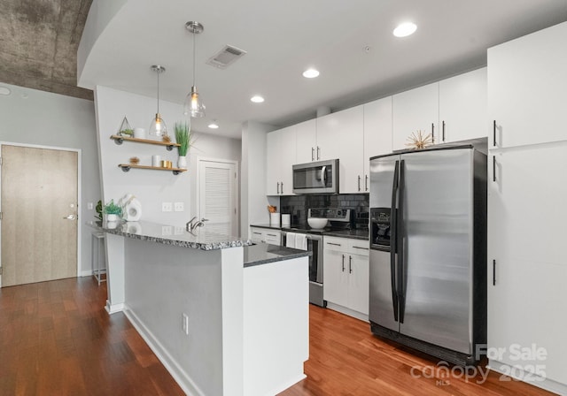 kitchen with a peninsula, visible vents, appliances with stainless steel finishes, open shelves, and dark wood finished floors