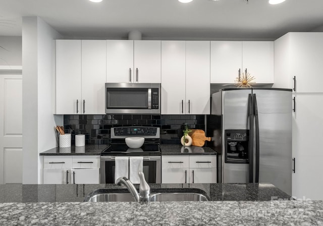 kitchen featuring white cabinets, tasteful backsplash, stainless steel appliances, and a sink