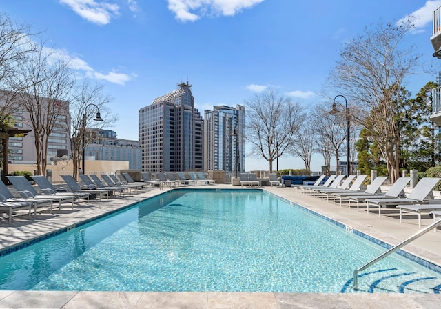 community pool with a city view and a patio