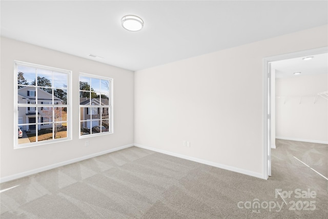 unfurnished room featuring carpet floors and baseboards