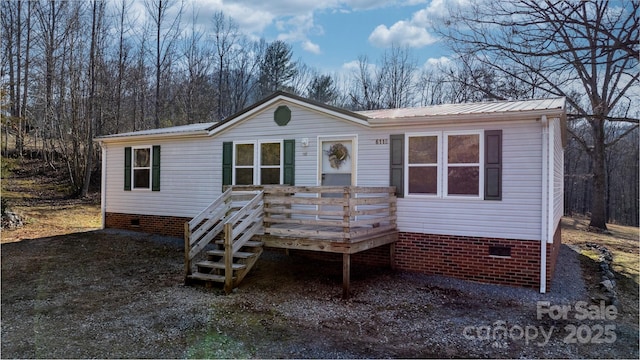 manufactured / mobile home with a deck, metal roof, and crawl space