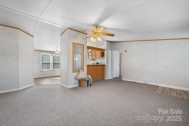 unfurnished living room with a ceiling fan, lofted ceiling, a textured ceiling, and carpet