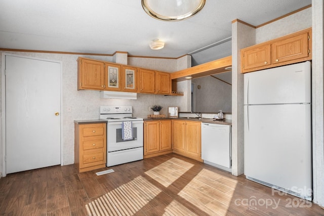 kitchen with white appliances, visible vents, dark wood finished floors, vaulted ceiling, and crown molding