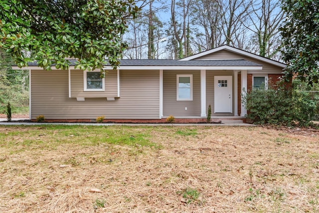 ranch-style house with covered porch and a front lawn