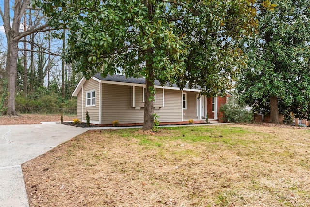 ranch-style house with driveway and a front lawn