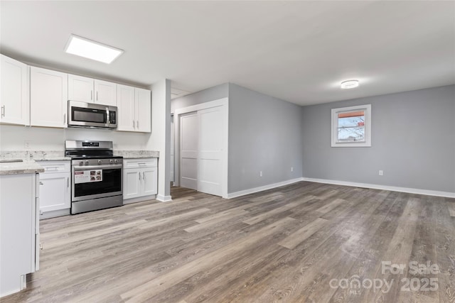 5329 Southampton Rd, Charlotte, NC 28217 - kitchen with stainless steel appliances, white cabinets, light wood-style floors, and baseboards