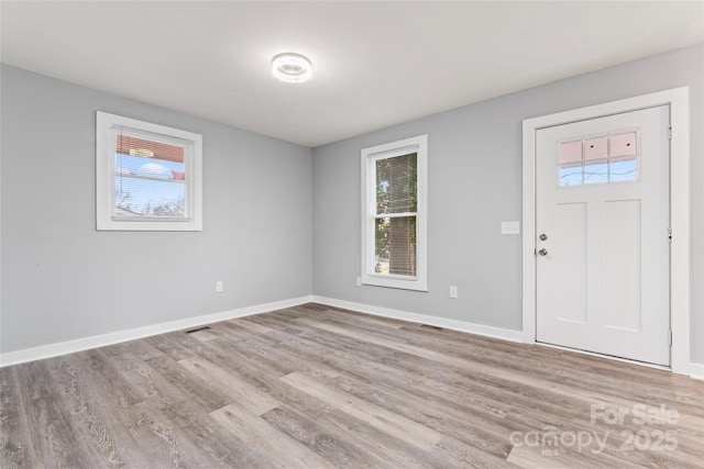 entryway with visible vents, baseboards, and wood finished floors