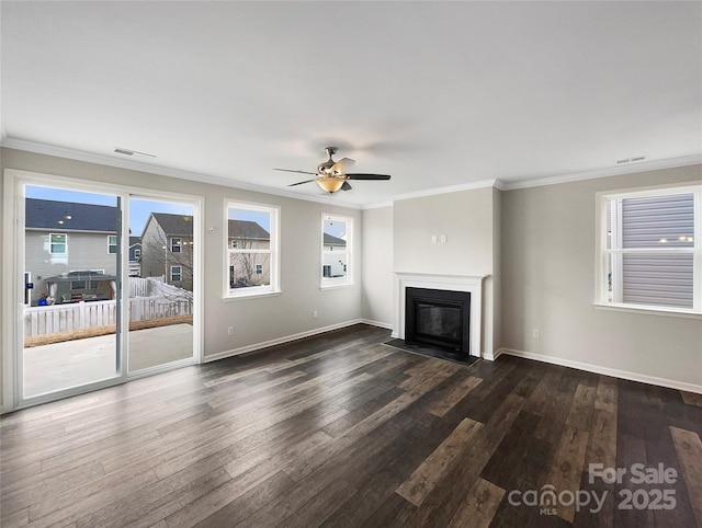 unfurnished living room featuring dark wood-style floors, a glass covered fireplace, crown molding, and baseboards