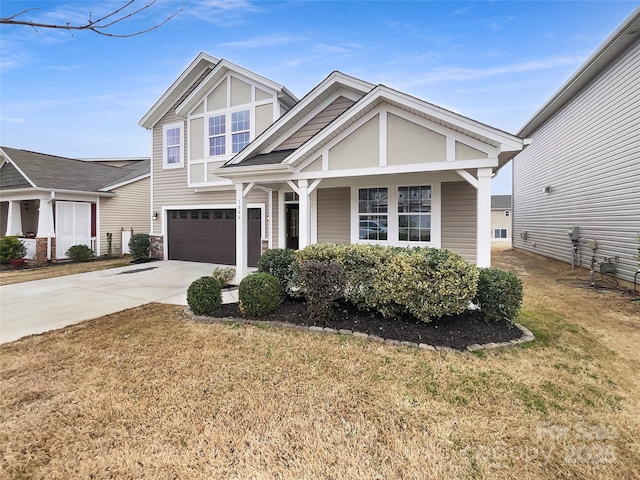 view of front facade featuring concrete driveway, an attached garage, and a front yard