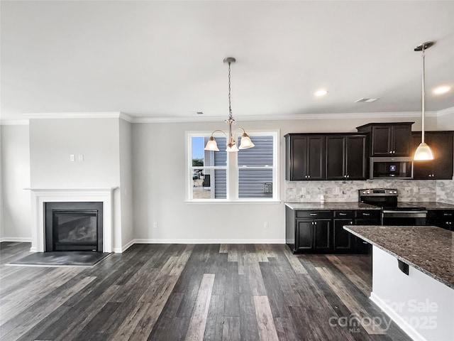 kitchen with dark wood-style floors, appliances with stainless steel finishes, a fireplace with flush hearth, and decorative backsplash