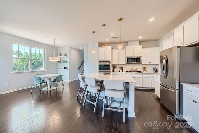 kitchen with light countertops, appliances with stainless steel finishes, dark wood finished floors, and white cabinets