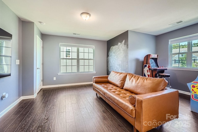 living area featuring a healthy amount of sunlight, visible vents, and dark wood finished floors