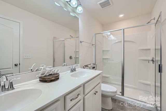 bathroom with toilet, a shower stall, visible vents, and a sink