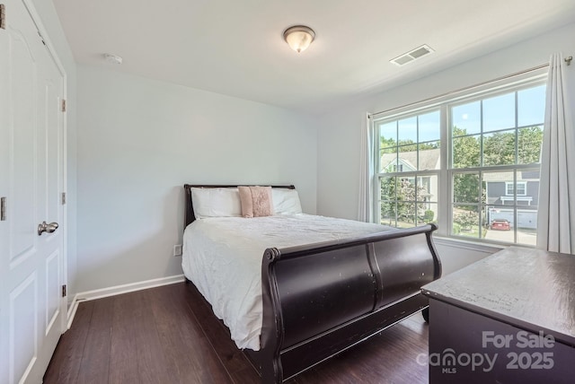 bedroom with baseboards, visible vents, and dark wood-type flooring