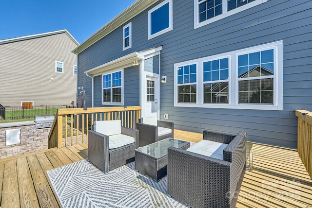 deck featuring fence, an outdoor living space, and area for grilling