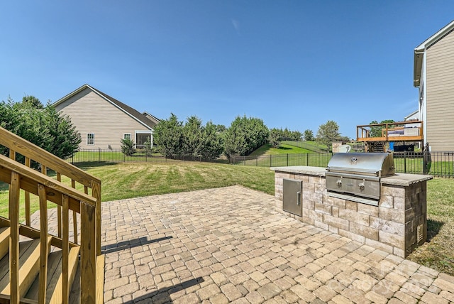 view of patio featuring a fenced backyard, exterior kitchen, and area for grilling