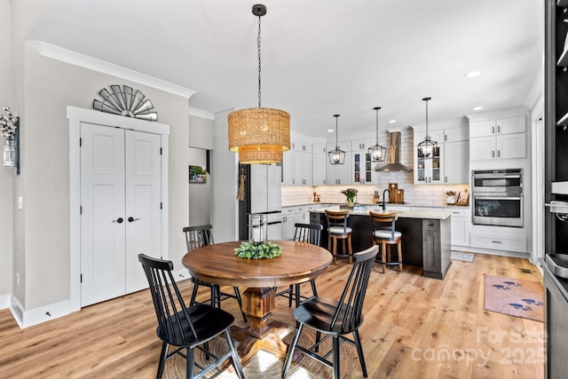 dining area with baseboards, ornamental molding, recessed lighting, and light wood-style floors