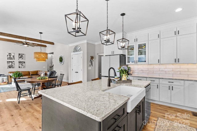 kitchen featuring pendant lighting, ornamental molding, freestanding refrigerator, and white cabinets