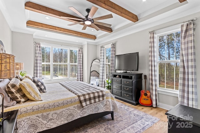 bedroom featuring light wood finished floors, multiple windows, and beamed ceiling