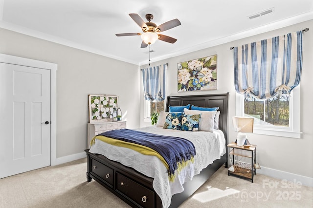 carpeted bedroom featuring crown molding, visible vents, ceiling fan, and baseboards