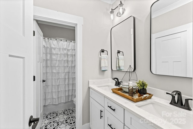 bathroom featuring double vanity, a sink, toilet, and a shower with curtain