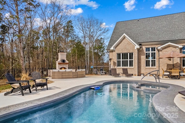 view of swimming pool with a pool with connected hot tub, a patio area, fence, and an outdoor living space with a fireplace