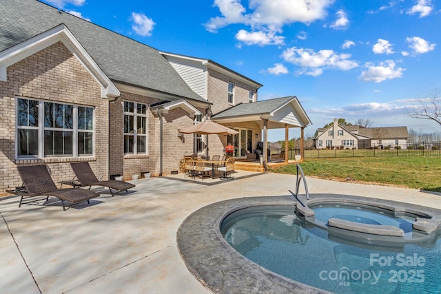 view of swimming pool with a patio area, a hot tub, fence, and a lawn