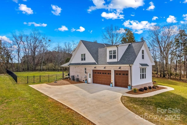 view of property exterior featuring roof with shingles, concrete driveway, a lawn, central AC unit, and fence