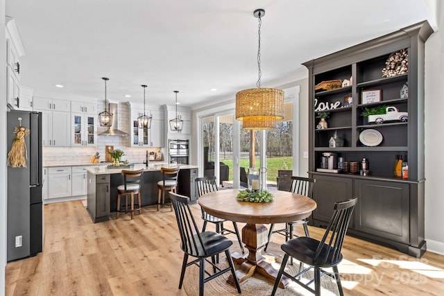 dining space with light wood-style floors and recessed lighting