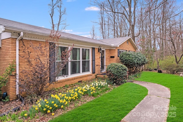 view of home's exterior featuring a yard and brick siding