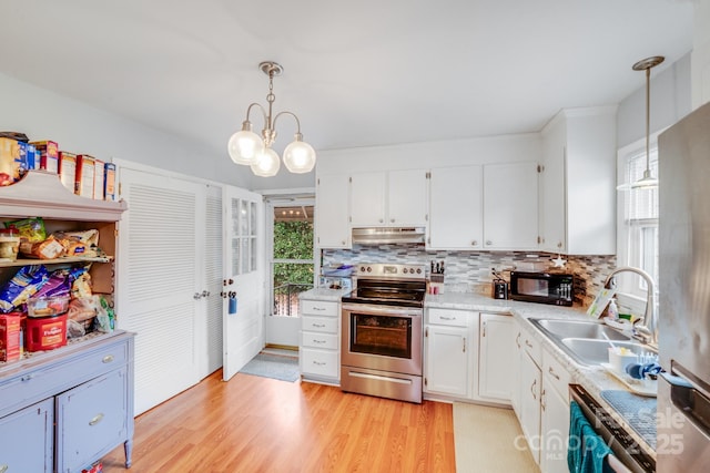 kitchen with under cabinet range hood, white cabinetry, appliances with stainless steel finishes, and a sink