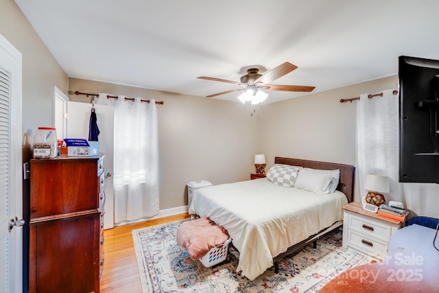 bedroom featuring light wood-type flooring, baseboards, and a ceiling fan