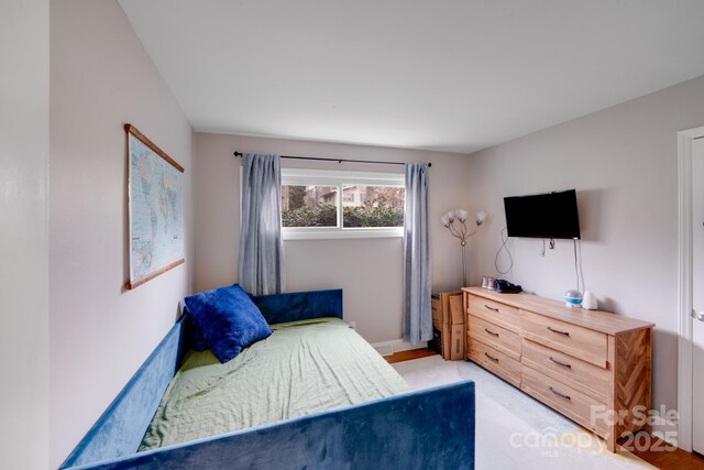 bedroom with baseboards and light carpet