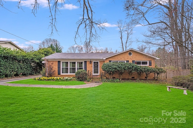 view of front of house with a front lawn, fence, brick siding, and crawl space