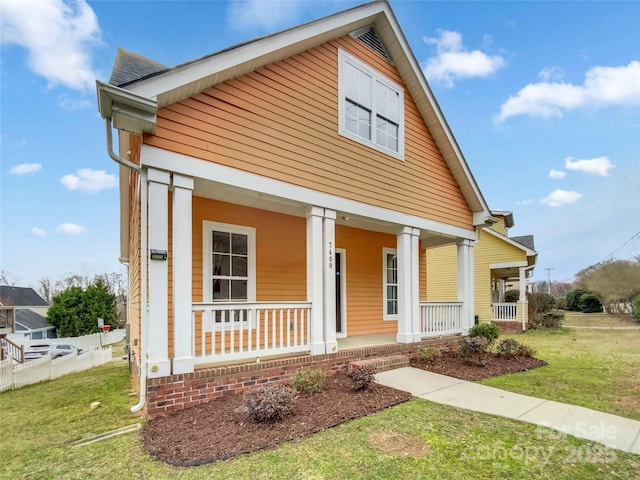 view of front of home with covered porch and a front yard